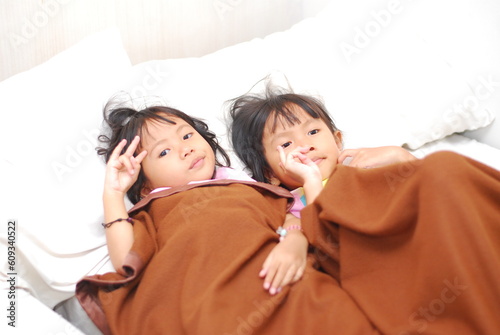 two beautiful Asian girls watching TV in the room while scared