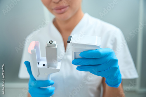 Woman beautician with a massage liftin apparatus in her hands photo