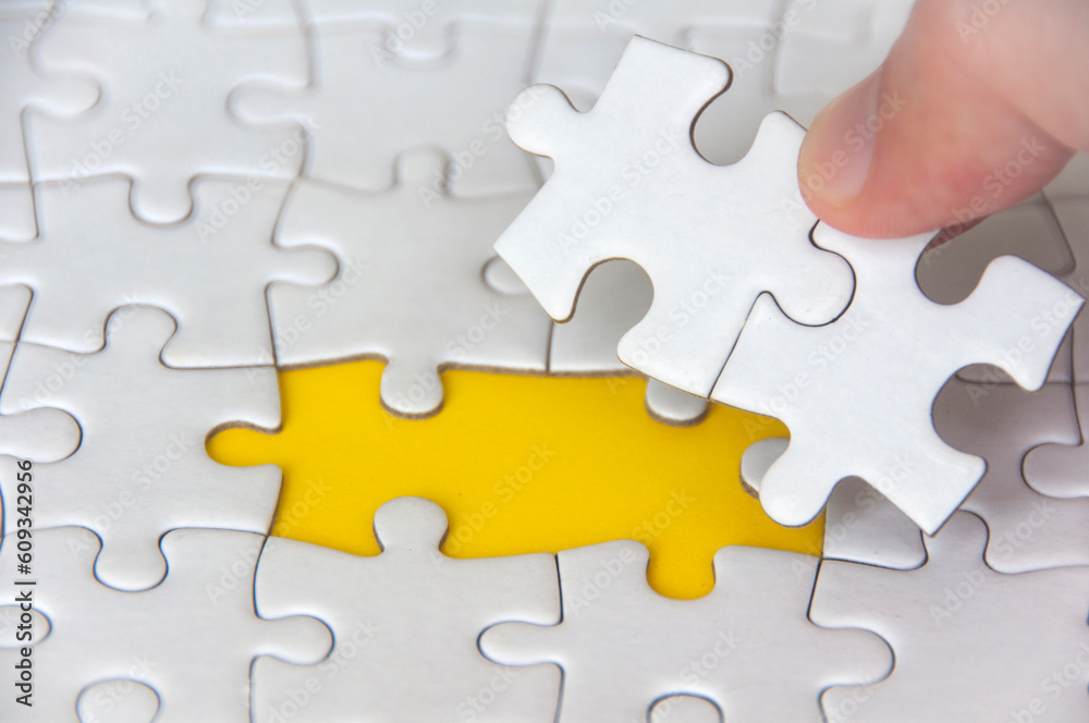 Hand holding separated jigsaw puzzle with customizable space for text. Copy space.