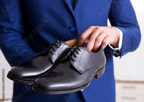 Young handsome businessman choosing shoes at home