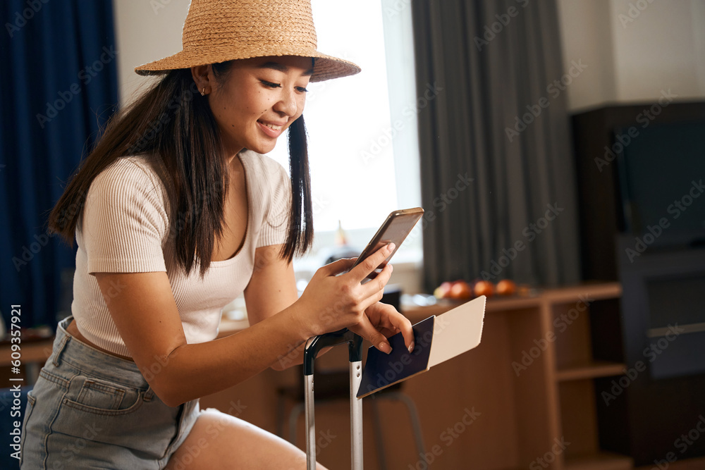 Happy female in hat using phone in the hotel Happy female in hat using phone in the hotel