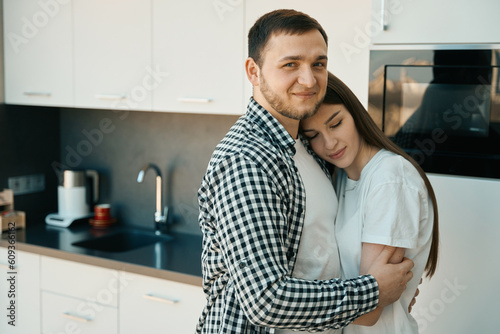 Smiling bearded man tenderly hugging his wife