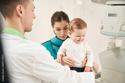 Experienced radiologist preparing child for diagnostic x-ray procedure
