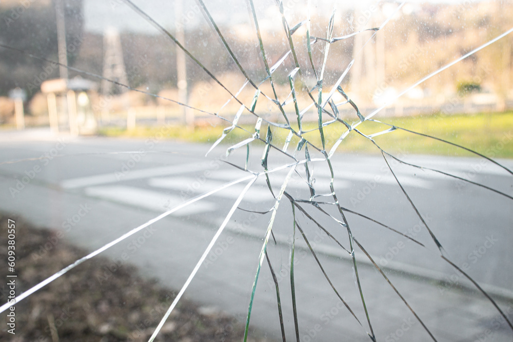 A glass window of a car punched by an angry people who hits a punch, a