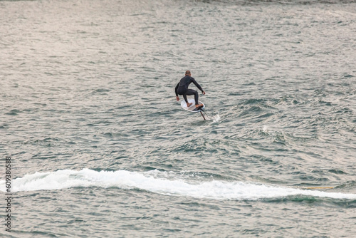 Canvas Print male surfer in action with an airfoil surfboard flying above the Atlantic Sea at