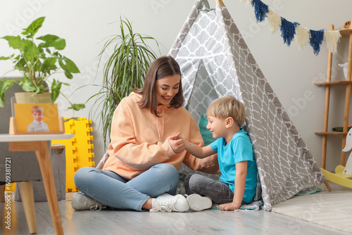 Nanny playing with little boy at home photo