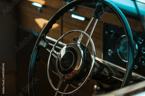 Steering wheel in a classic car, old automobile, vintage vehicle interior, wooden traditional cars dashboard dials, speed clocks speedo
