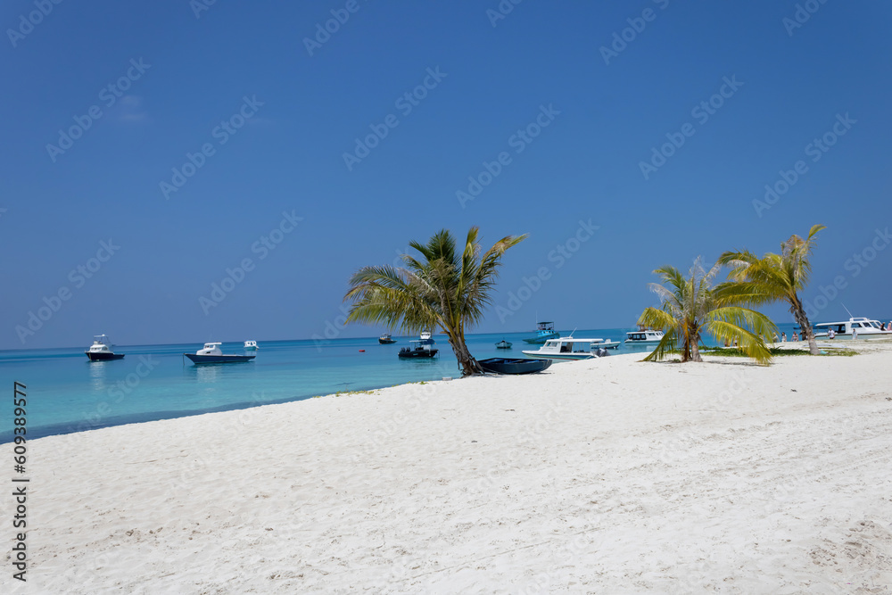 A white sand beach on Fulidhoo with moored boats, Maldives
