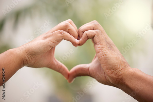 Heart, hands sign and couple outdoor for care, affection or bonding together. Love, hand gesture and man and woman support, trust or empathy, kindness and emoji for commitment, marriage and loyalty. © L Ismail/peopleimages.com