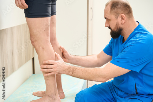 Surgeon examining patient legs in the hospital
