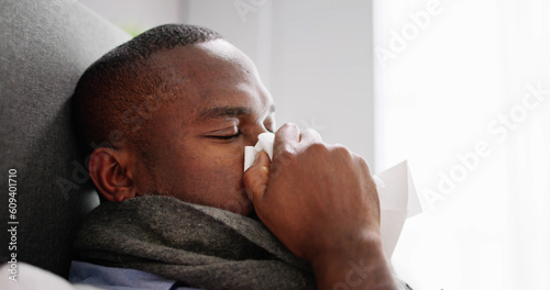Young Man Infected With Cold Blowing His Nose