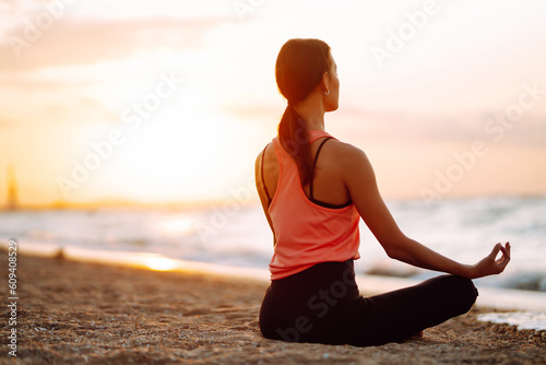 Portrait of young woman do meditation around sea beach ocean at sunrise for health. Sport, Active life.