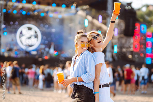 Happy girlfriends having fun at music festival. Summer holiday, vacation concept. Friendship and celebration concept. photo