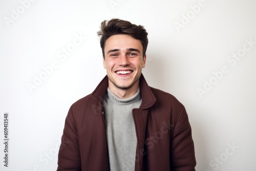 Portrait of a handsome young man smiling against a white background.