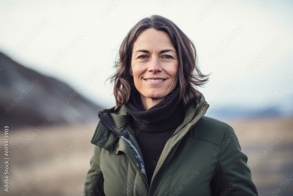 Portrait of smiling woman standing in field on a cold winter day Portrait of smiling woman standing in field on a cold winter day