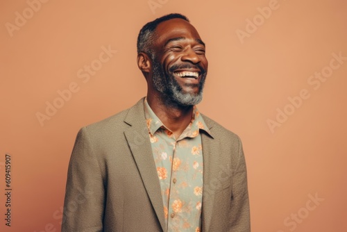 Happy african american man laughing and looking up on orange background