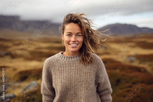 Portrait of a smiling woman with hair in the wind in Iceland
