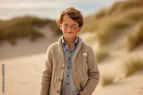 Portrait of a young boy standing in the sand dunes at sunset