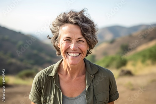 Portrait of a happy senior woman smiling while standing in the countryside
