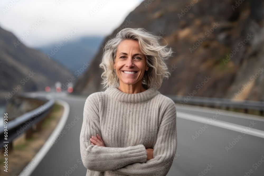 Portrait of a happy senior woman standing with arms crossed on a highway in Norway Portrait of a happy senior woman standing with arms crossed on a highway in Norway