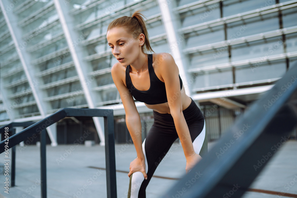 Obraz premium Young woman in sports outfit doing exercises outdoors in the morning. Sport, Active life, sports training, healthy lifestyle.
