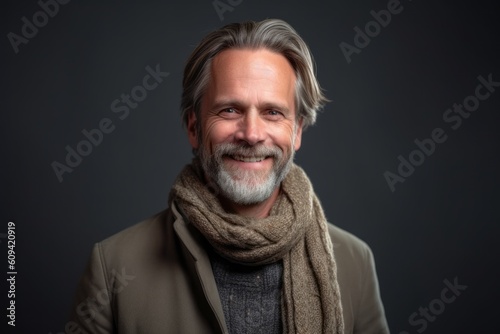 Portrait of a handsome middle-aged man with gray hair and a gray scarf.