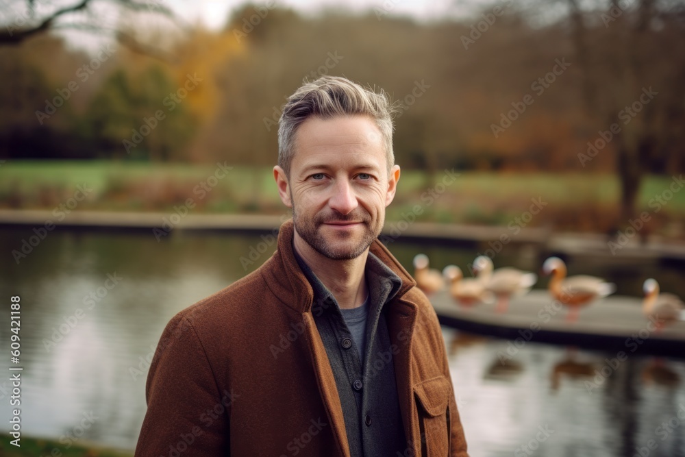 Portrait of a handsome young man in a park with ducks. Portrait of a handsome young man in a park with ducks.