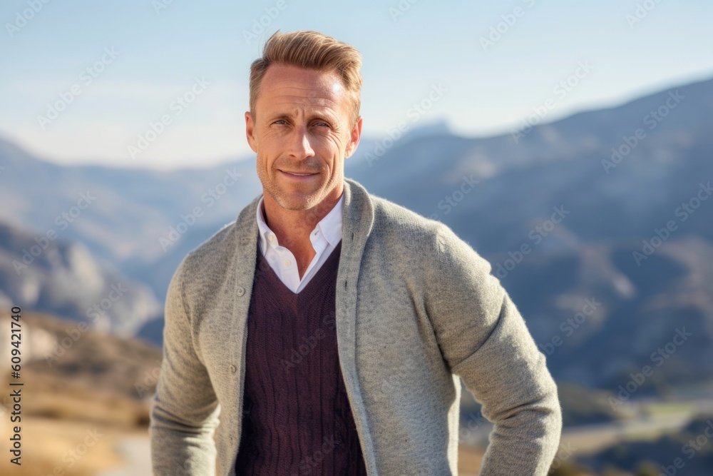 Medium shot portrait photography of a pleased man in his 40s that is wearing a chic cardigan against a beautiful and breathtaking mountain vista background . Generative AI Medium shot portrait photography of a pleased man in his 40s that is wearing a chic cardigan against a beautiful and breathtaking mountain vista background . Generative AI