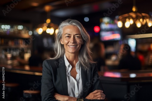 Portrait of senior businesswoman in a bar, looking at camera.