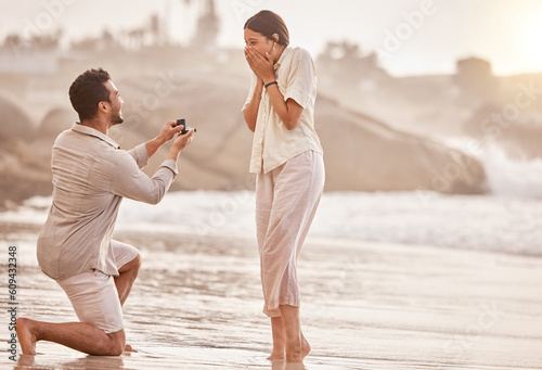 Couple at beach, wow for proposal and engagement with love and commitment with ocean and people outdoor. Travel, mockup space and man propose marriage to woman, surprise and happiness with care