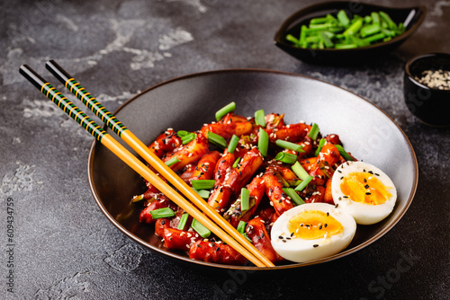 Tteokbokki, Teopokki fried rice cake in black bowl. photo