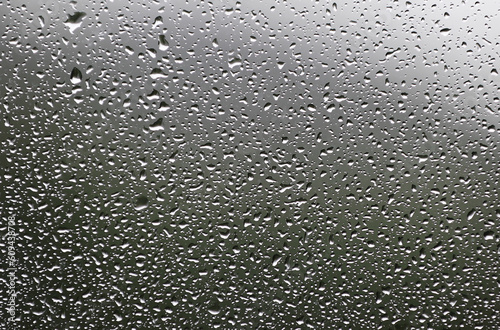 Tiny water drops on glass window on a rainy day. Selective focus used. 