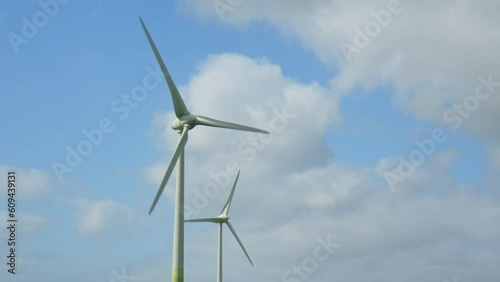 Two Wind Turbines against a blu summer sky with some clouds on a windy day in East Frisia, Lower Saxony, Germany. 2023 photo