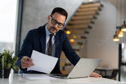 Portrait of handsome businessman doing some paperwork at office