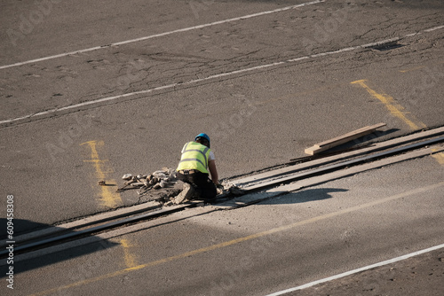 A man engaged in the maintenance of the quay. Stevedore in the port. Safety in the port during cargo operation. Road maintenance in the middle of the highway. Traffic affected by the work on road.