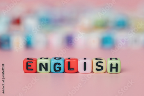 The word ENGLISH from letter beads on pink background for education and learning concept, selective focus image