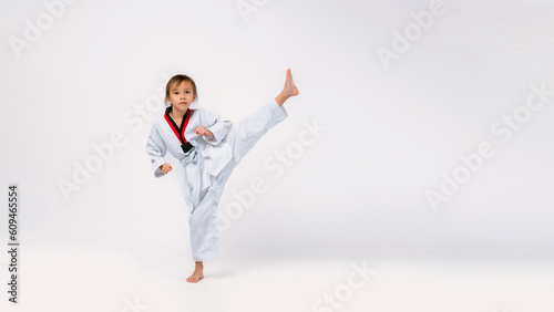 Banner: Asian-Australian girl poses in martial arts Practice taekwondo, karate, judo against a White background in the studio. Asian kids karate or Taekwondo martial arts. Sport kid training action.