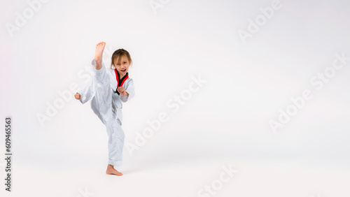 Banner: Asian-Australian girl poses in martial arts Practice taekwondo, karate, judo against a White background in the studio. Asian kids karate or Taekwondo martial arts. Sport kid training action. © VR Studio