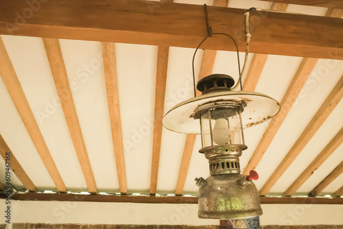 Classic shaped Electric paraffin pressure lamps or kerosene lamp pressure lantern. Old traditional storm lamps attached on javanese joglo limasan house wooden ceilings. Copy text empty blank space. photo