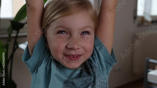 Sleepy child girl with snot yawns raising hands up