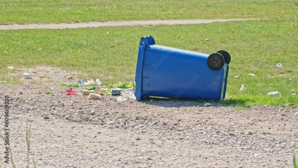 Tipped Over Plastic Garbage Container on Grass Field Parking Lot during Public Event Open Air Music Festival Tipped Over Plastic Garbage Container on Grass Field Parking Lot during Public Event Open Air Music Festival