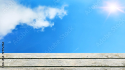 white wooden table at the front with clear blue sky with sunshine for using as background for product display