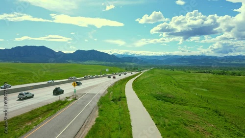 As vehicles seamlessly merge onto Highway 36, a picturesque scene unfolds with the stunning backdrop of Boulder, Colorado in the distance.