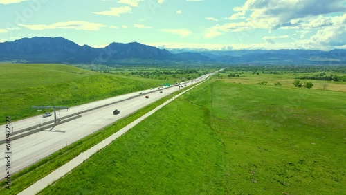 In this captivating drone shot, the camera smoothly tracks two cyclists as they pedal along the picturesque Highway 36, gradually making their way towards the mesmerizing city of Boulder, Colorado.