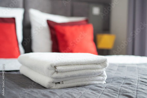 clean terry towels on bed in hotel room, closeup © k0teika