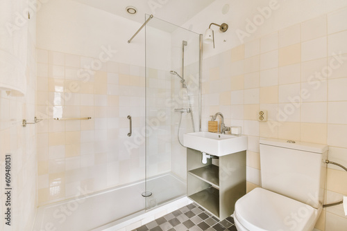 a bathroom with a toilet, sink and shower stall in the corner next to it is a checkered tiled floor