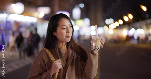 Woman enjoy bubble milk tea in street market of Taiwan photo