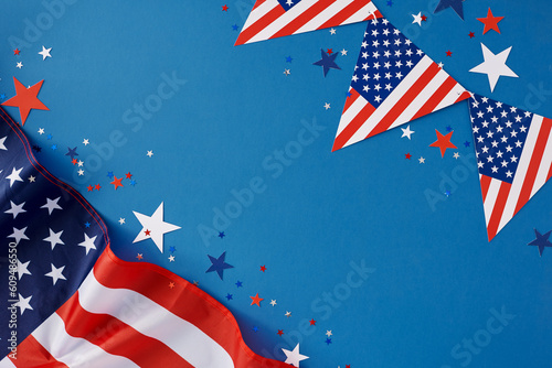 Happy Independence Day of America concept. Top view flat lay of american flag, flag garlands, patriotic party confetti on blue background with empty space for text or ads