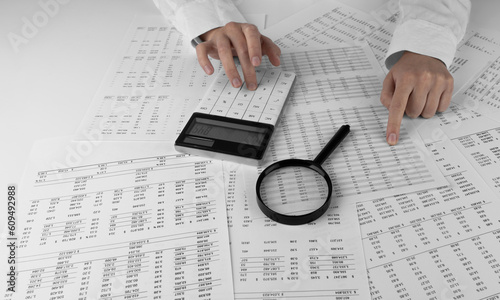 Canvas Print Accountant holding a calculator pointing at numbers on financial documents
