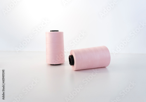 Two spools of pink thread. Accessories for sewing and needlework. Sewing production concept.